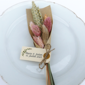 Mini bouquet de fleurs séchées dans les tons rose poudrée emballé dans un papier kraft avec une étiquette personnalisée
