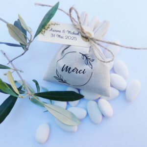 Pochon en coton personnalisé avec une illustration "Merci" couronne fleurs et une étiquette personnalisée. Le pochon est garni de 15 dragées.