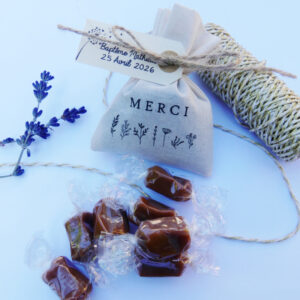 Pochon en coton personnalisé avec une illustration "Merci" Petites Fleurs et une étiquette personnalisée. Le pochon contient 5 caramels au beurre salé