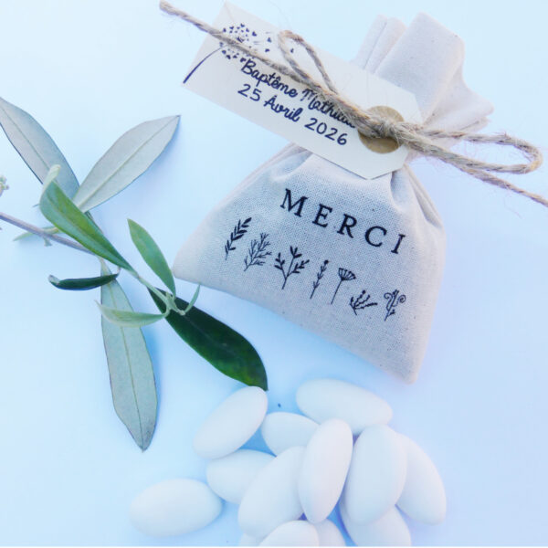Pochon en coton personnalisé avec une illustration "Merci" Petites Fleurs et une étiquette personnalisée. Le pochon est garni de 15 dragées.